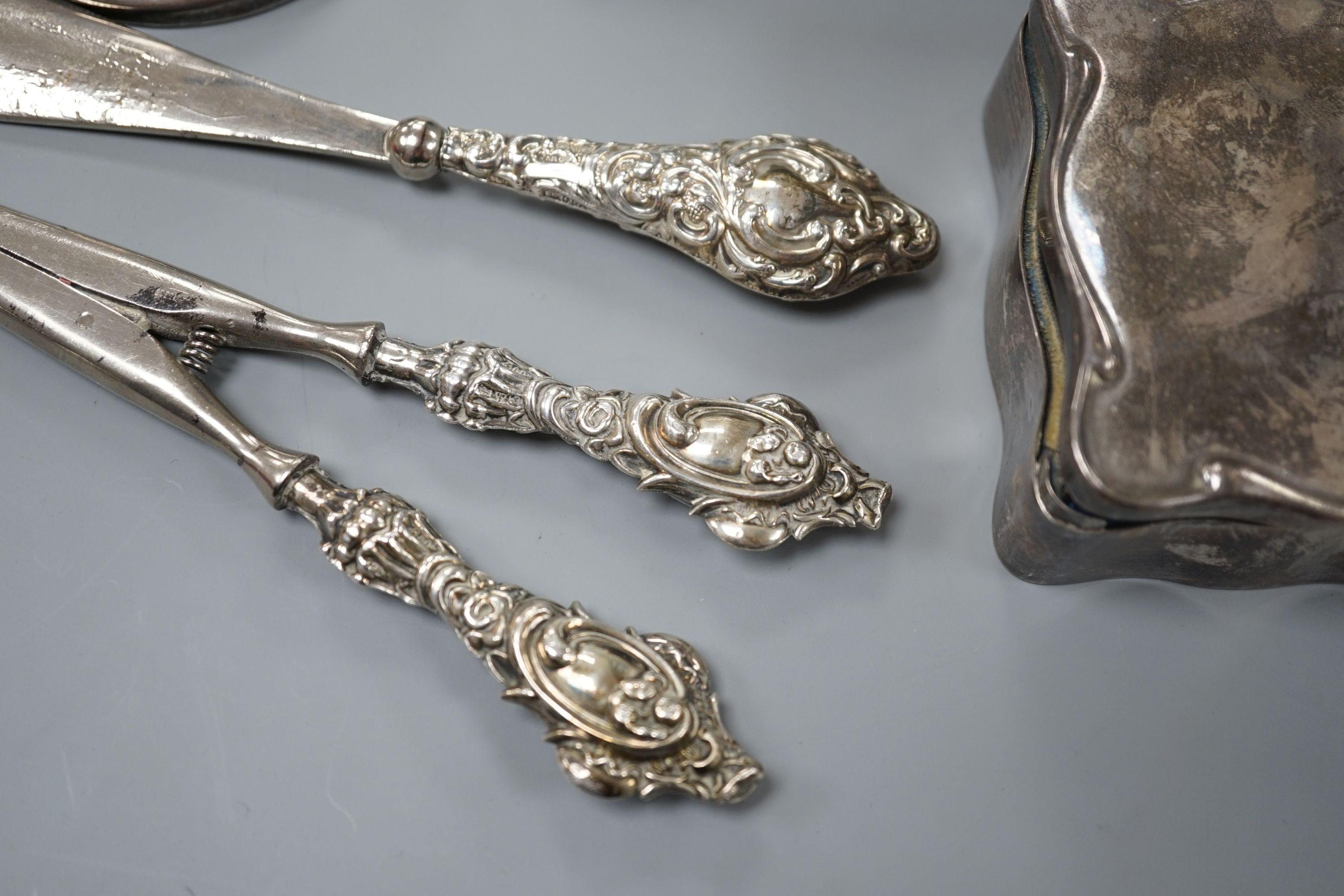 A George V silver mounted hat pin stand, two silver spoons, a silver mounted trinket box, a pair of glove stretchers and a shoe horn.